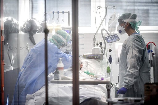 FILE - In this Thursday, March 19, 2020, file photo, medical personnel work in the intensive care unit of a hospital in Brescia, Italy. World War II references are now heard daily, not because another momentous 75th anniversary, Victory in Europe Day approaches in May but because of the coronavirus. (Claudio Furlan/LaPresse via AP, File)