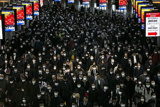 FILE - In this Tuesday, March 3, 2020, file photo, a large crowd wearing masks commutes through Shinagawa Station in Tokyo. World War II references are now heard daily, not because another momentous 75th anniversary, Victory in Europe Day approaches in May but because of the coronavirus. (AP Photo/Jae C. Hong, File)