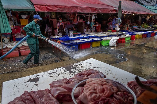 A sanitation worker uses a high-pressure water source to wash a market in Bangkok, Thailand, Wednesday, March 25, 2020. Thailand&#146;s government announced Tuesday it will declare an emergency later in the week allowing them to take stricter measures to control the coronavirus outbreak that has infected hundreds of people in the Southeast Asian country. For most people, the new coronavirus causes only mild or moderate symptoms. For some, especially older adults it can cause more severe illness. (AP Photo/Gemunu Amarasinghe)