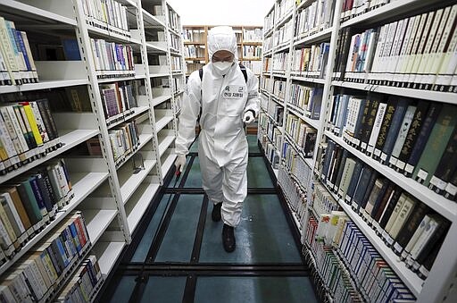 An army soldier sprays disinfectant to curb the spread of the coronavirus at a library in Daegu, South Korea, Wednesday, March 25, 2020. For most people, the new coronavirus causes only mild or moderate symptoms, such as fever and cough. For some, especially older adults and people with existing health problems, it can cause more severe illness, including pneumonia.(Kim Hyun-tae/Yonhap via AP)