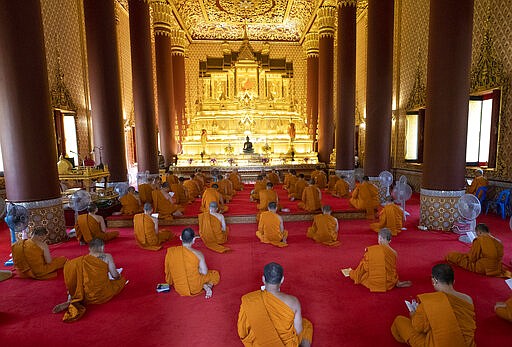 Buddhist monks wear face masks to protect themselves from the coronavirus as they pray for good luck at Debsirin Temple in Bangkok, Thailand, Wednesday, March 23, 2020. Thailand's government agreed to declare an emergency to take stricter measures to control the coronavirus outbreak that has infected hundreds of people in the Southeast Asian country.  (AP Photo/Sakchai Lalit)