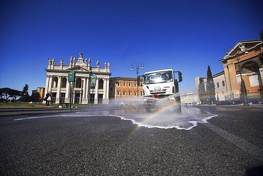 A truck sprays disinfectant as a preventive measure against the spread of the new coronavirus, in Rome, Wednesday, March 25, 2020. The new coronavirus causes mild or moderate symptoms for most people, but for some, especially older adults and people with existing health problems, it can cause more severe illness or death. (AP Photo/Andrew Medichini)