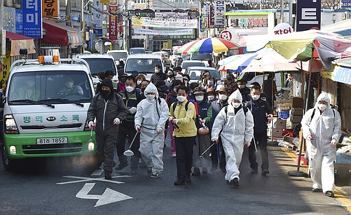 Residents spray disinfectant as a precaution against a new coronavirus at a traditional market in Suwon, South Korea, Wednesday, March 25, 2020. For most people, the new coronavirus causes only mild or moderate symptoms, such as fever and cough. For some, especially older adults and people with existing health problems, it can cause more severe illness, including pneumonia.(Kim Jong-taek/Newsis via AP)