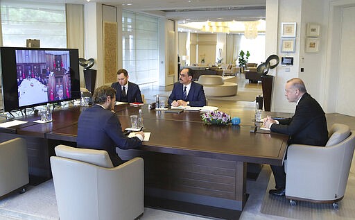 In this photo released by Turkish Presidency, President Recep Tayyip Erdogan, right, and his advisors participate in a teleconference with his ministers amid the coronavirus outbreak, in Istanbul, Wednesday, March 25, 2020. The new coronavirus causes mild or moderate symptoms for most people, but for some, especially older adults and people with existing health problems, it can cause more severe illness or death.(Turkish Presidency via AP, Pool)