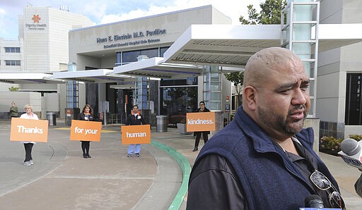 FILE - In this Monday, March 23, 2020, photo Tejon Tribe representative Octavio Escobedo speaks with local television station as Dignity Health staff thank the Tribe in the background at Dignity Health Mercy and Memorial Hospitals in Bakersfield, Calif. The Tejon Indian Tribe lead by Chairman Escobedo donated 1,400 N95 particulate masks from the Tejon Indian Tribe Health Services. (Alex Horvath/The Bakersfield Californian via AP)