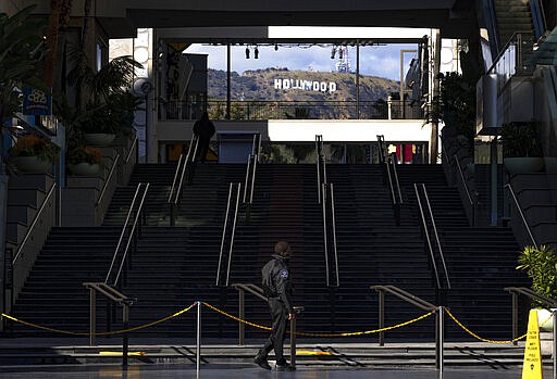 Security officers guard the closed Hollywood &amp; Highland Center shopping mall and entertainment complex in Los Angeles, Tuesday, March 24, 2020, as the U.S. continues to face the new coronavirus pandemic. (AP Photo/Damian Dovarganes)