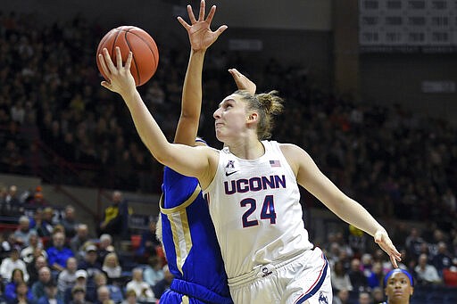 FILE - In this Sunday, Jan. 19, 2020, file photo, Connecticut's Anna Makurat (24) shoots during the first half of an NCAA college basketball game against Tulsa, in Storrs, Conn. Makurat, from Poland, is one of more than 20,000 foreign athletes currently competing at NCAA schools, according to the organization. With competition canceled across all NCAA divisions because of the new coronavirus, many of those athletes face a dilemma. Their campuses are shut down, but the coronavirus situation in their homeland may be worse than it is in the United States. (AP Photo/Stephen Dunn, File)