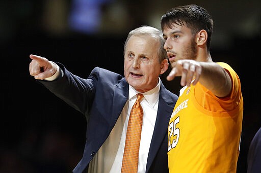 FILE - In this Saturday, Jan. 18, 2020, file photo, Tennessee coach Rick Barnes talks with guard Santiago Vescovi during the second half of the team's NCAA college basketball game against Vanderbilt in Nashville, Tenn. Vescovi, from Uruguay, is one of several international players on the Tennessee team, which also has players from France, Serbia and Finland. With competition canceled across all NCAA divisions because of the new coronavirus, many of these international athletes face a dilemma. Their campuses are shut down, but the coronavirus situation in their homeland may be worse than it is in the United States. (AP Photo/Mark Humphrey, File)