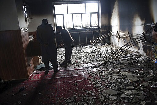 Afghan Sikhs inspect inside a Sikh house of worship, in the aftermath of an attack in Kabul, Afghanistan, Wednesday, March 25, 2020. The Interior Ministry said a lone Islamic State gunman rampaged through the Sikh place of worship, called Gurdwara, in the heart of the Afghan capital on Wednesday, killing over 20 worshippers and wounding others. It said that the gunman held many of the worshippers hostage for several hours as Afghan special forces, helped by international troops, tried to clear the building. (AP Photo/Rahmat Gul)