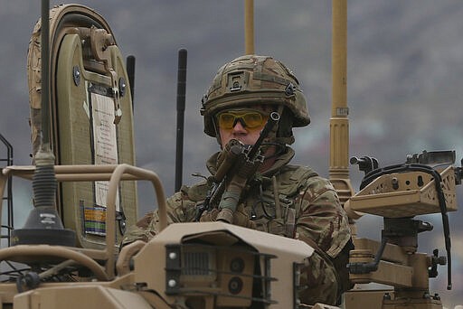 A British soldier with NATO-led Resolute Support Mission forces arrives at the site of an attack in Kabul, Afghanistan, Wednesday, March 25, 2020. Gunmen stormed a religious gathering of Afghanistan's minority Sikhs in their place of worship in the heart of the Afghan capital's old city on Wednesday, a minority Sikh parliamentarian said. (AP Photo/Rahmat Gul)