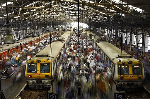 FILE - In this Feb. 11, 2013, file photo, Indian commuters get off trains at the Church Gate railway station in Mumbai, India. India's colossal passenger railway system has come to a halt Sunday, March 22, 2020, as officials take emergency measures to keep the coronavirus pandemic from spreading in the country of 1.3 billion. The railway system is often described as India's lifeline, transporting 23 million people across the vast subcontinent each day, some 8.4 billion passengers each year. (AP Photo/Rafiq Maqbool, File)