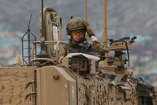 A British soldier with NATO-led Resolute Support Mission forces arrives at the site of an attack in Kabul, Afghanistan, Wednesday, March 25, 2020. Gunmen stormed a religious gathering of Afghanistan's minority Sikhs in their place of worship in the heart of the Afghan capital's old city on Wednesday, a minority Sikh parliamentarian said. (AP Photo/Rahmat Gul)