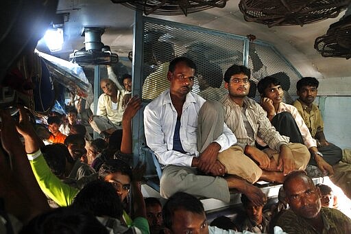 FILE - In this Monday, Oct. 31, 2011, file photo, Indian passengers travel in an overcrowded train at the New Delhi railway station, in New Delhi, India. India's colossal passenger railway system has come to a halt Sunday, March 22, 2020, as officials take emergency measures to keep the coronavirus pandemic from spreading in the country of 1.3 billion. The railway system is often described as India's lifeline, transporting 23 million people across the vast subcontinent each day, some 8.4 billion passengers each year. (AP Photo/Manish Swarup, File)