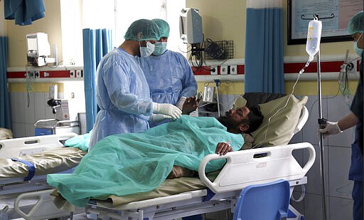 An Afghan Sikh man wounded in a gunmen attack is treated in a hospital in Kabul, Afghanistan, Wednesday, March 25, 2020. Gunmen stormed a religious gathering of Afghanistan's minority Sikhs in their place of worship in the heart of the Afghan capital's old city on Wednesday, a minority Sikh parliamentarian said. (AP Photo/Tamana Sarwary)