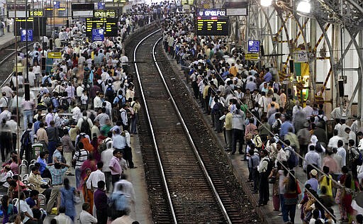 FILE - In this Wednesday, July 11, 2012, file photo, Indian commuters wait for trains at the Churchgate railway station in Mumbai, India. India's colossal passenger railway system has come to a halt Sunday, March 22, 2020, as officials take emergency measures to keep the coronavirus pandemic from spreading in the country of 1.3 billion. The railway system is often described as India's lifeline, transporting 23 million people across the vast subcontinent each day, some 8.4 billion passengers each year. (AP Photo/Rajanish Kakade, File)