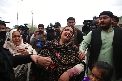 Family members cry after an attack in Kabul, Afghanistan, Wednesday, March 25, 2020. Gunmen stormed a religious gathering of Afghanistan's minority Sikhs in their place of worship in the heart of the Afghan capital's old city on Wednesday, a minority Sikh parliamentarian said. (AP Photo/Rahmat Gul)