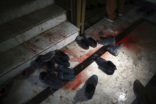 Blood stains and shoes remain on stairs inside a Sikh house of worship, in the aftermath of an attack in Kabul, Afghanistan, Wednesday, March 25, 2020. The Interior Ministry said a lone Islamic State gunman rampaged through the Sikh place of worship, called Gurdwara, in the heart of the Afghan capital on Wednesday, killing over 20 worshippers and wounding others. It said that the gunman held many of the worshippers hostage for several hours as Afghan special forces, helped by international troops, tried to clear the building. (AP Photo/Rahmat Gul)