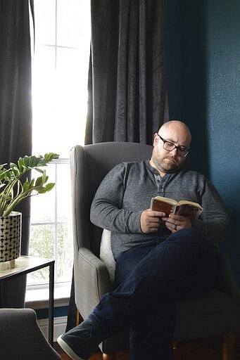 In this photo provided by Brett Seidl, Jonathon Seidl sits in his home office in Dallas on Wednesday, March 18, 2020. He said he wasn't worried about the coronavirus despite his anxiety disorder. But that changed. The 33-year-old digital media strategist, who takes medication, said his concern was less about getting sick than about the battering the economy could sustain. Would he be able to feed his family? Would there be a run on food stores? He could not shake his worries. (Brett Seidl via AP)