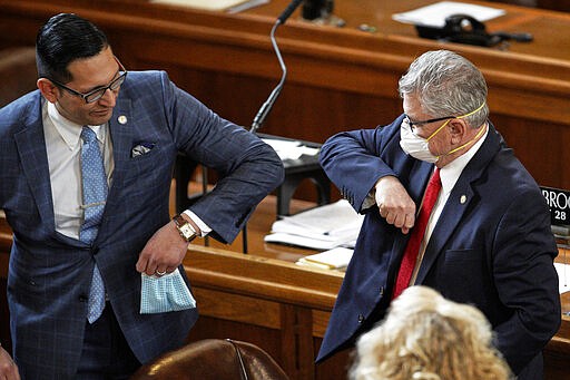 FILE - In this March 23, 2020, file photo Nebraska Senators Tony Vargas of Omaha, left, and Mark Kolterman of Seward, bump elbows at the State Capitol in Lincoln, Neb. (AP Photo/Nati Harnik, File)