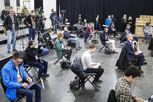 FILE - In this March 24, 2020, file photo journalists practice social distancing during a news conference with New York Gov. Andrew Cuomo at the Jacob Javits Center that will house a temporary hospital in response to the COVID-19 outbreak in New York. (AP Photo/John Minchillo, File)