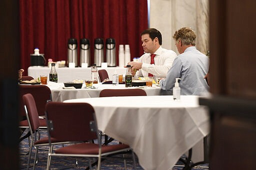 In this March 20, 2020, photo Sen. Rand Paul, R-Ky., right, Sen. Marco Rubio, R-Fla., left, have lunch at a Republican policy lunch on Capitol Hill in Washington. Paul tested positive for the coronavirus. (AP Photo/Susan Walsh)