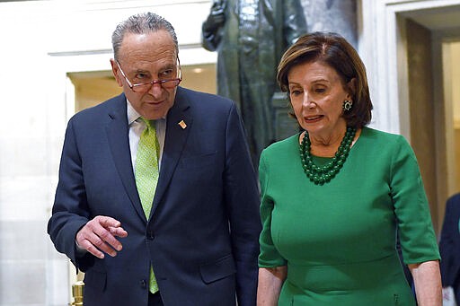 FILE - In this March 12, 2020, file photo Senate Minority Leader Sen. Chuck Schumer of N.Y., and House Speaker Nancy Pelosi of Calif., walks together as they head to a lunch with Irish Prime Minister Leo Varadkar on Capitol Hill in Washington. (AP Photo/Susan Walsh, File)