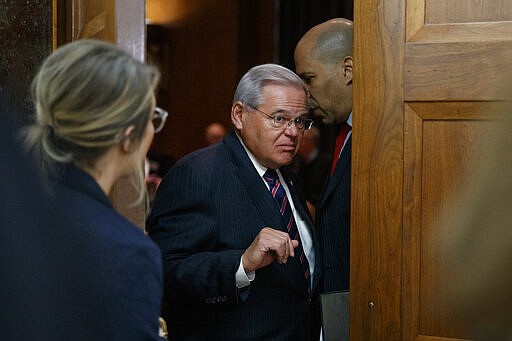 FILE - In this March 12, 2020, file photo Sen. Bob Menendez, D-N.J., second from left, pauses to listen to Sen. Cory Booker, D-N.J., as they depart a briefing on Capitol Hill in Washington on the coronavirus outbreak. (AP Photo/Carolyn Kaster, File)