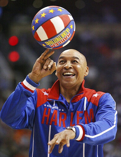 The Harlem Globetrotters' Fred &quot;Curly&quot; Neal performs during a timeout in the second quarter in an NBA basketball game between the Indiana Pacers and the Phoenix Suns in Phoenix. Neal, the dribbling wizard who entertained millions with the Harlem Globetrotters for parts of three decades, has died the Globetrotters announced Thursday, March 26, 2020. He was 77. Neal played for the Globetrotters from 1963-85, appearing in more than 6,000 games in 97 countries for the exhibition team known for its combination of comedy and athleticism. (AP Photo/Ross D. Franklin, File)