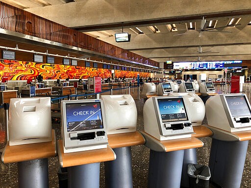 The departure lobby at Honolulu's Daniel K. Inouye International Airport has few travelers Thursday, March 26, 2020 as the state of Hawaii imposed a 14-day traveler quarantine to slow the spread of the coronavirus. Travelers landed in Hawaii to a new requirement that they hole up in hotel rooms or their homes for 14 days to fight the spread of the virus. (AP Photo/Audrey McAvoy)