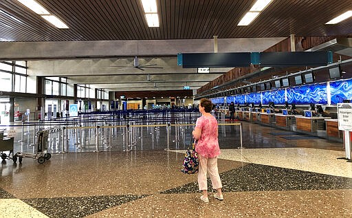 Few people are in the departure lobby at Honolulu's Daniel K. Inouye International Airport on Thursday, March 26, 2020, as Hawaii imposed a 14-day traveler quarantine to slow the coronavirus. Travelers landed in Hawaii to a new requirement that they hole up in hotel rooms or their homes for 14 days to fight the spread of the virus. (AP Photo/Audrey McAvoy)