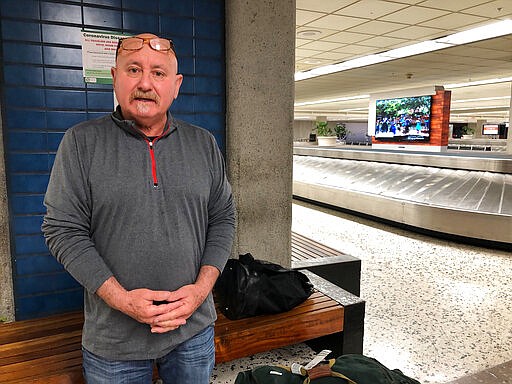 Traveler Armando Baiza speaks at Honolulu's Daniel K. Inouye International Airport on Thursday, March 26, 2020, after discovering he must enter a 14-day quarantine as the state of Hawaii tries to limit the coronavirus spread. (AP Photo/Audrey McAvoy)