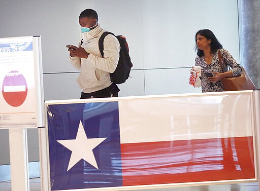 FILE - In this March 12, 2020, file photo, travelers make their way through Love Field airport in Dallas. Texas joined other states Thursday, March 26, 2020, in imposing quarantines on travelers from the New York area, the epicenter of the coronavirus outbreak in the U.S., and put similar restrictions on people arriving from nearby New Orleans as the number of cases there surges dramatically.(AP Photo/LM Otero)