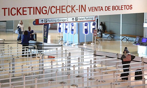 FILE - In this March 12, 2020, file photo, an empty security queue awaits travelers at Love Field airport in Dallas. Texas joined other states Thursday, March 26, 2020, in imposing quarantines on travelers from the New York area, the epicenter of the coronavirus outbreak in the U.S., and put similar restrictions on people arriving from nearby New Orleans as the number of cases there surges dramatically. (AP Photo/LM Otero, File)