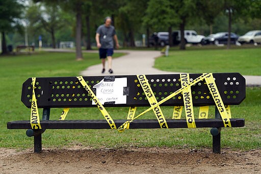 A park bench is cordoned off Wednesday, March 25, 2020, in Houston. A stay-at-home order was issued Tuesday for Houston and Harris County residents to help fight the spread of COVID-19. The new coronavirus causes mild or moderate symptoms for most people, but for some, especially older adults and people with existing health problems, it can cause more severe illness or death. (AP Photo/David J. Phillip)