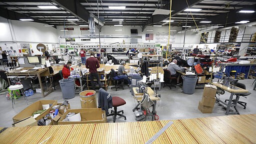 Workers sew face masks at SugarHouse Industries Thursday, March 26, 2020, in Midvale, Utah. SugarHouse Industries, a Utah company that usually manufactures boat tops and covers, has reconfigured its operation amid the spread of the coronavirus in order to produce face shields and masks. (AP Photo/Rick Bowmer)