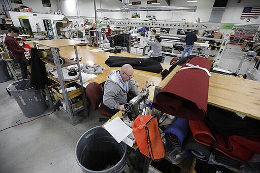 Workers sew face masks at SugarHouse Industries Thursday, March 26, 2020, in Midvale, Utah. SugarHouse Industries, a Utah company that usually manufactures boat tops and covers, has reconfigured its operation amid the spread of the coronavirus to produce face shields and masks. (AP Photo/Rick Bowmer)