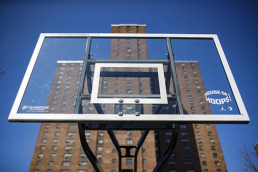 Basketball backboards stand without hoops after city officials had them removed to reduce gatherings at Holcombe Rucker Park, Thursday, March 26, 2020, in New York. Across the U.S., police departments are taking a lead role in enforcing social distancing rules that health officials say are critical to containing the coronavirus.  In New York City, they've started dismantling basketball hoops to prevent people from gathering in parks and playing. (AP Photo/John Minchillo)