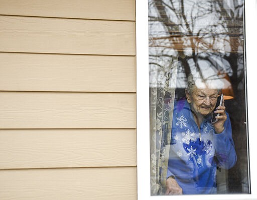 Marie DeBoer, 92, talks to her family on the phone on Monday, March 23, 2020 at Edgewood Assisted Living in Sioux Falls, S.D. Assisted living facilities across the city are limiting visitors to prevent the spread of COVID-19. (Abigail Dollins/The Argus Leader via AP)