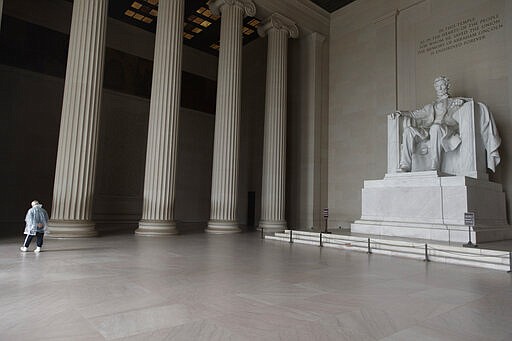 A lone visitor walks from viewing the Lincoln Memorial in Washington, Monday, March 23, 2020. As Washington, D.C. continues to work to mitigate the spread of the coronavirus (COVID-19), Mayor Muriel Bowser extended road closures and other measures to restrict access to the Tidal Basin the the cherry blossoms and other tourist attractions. (AP Photo/Carolyn Kaster)