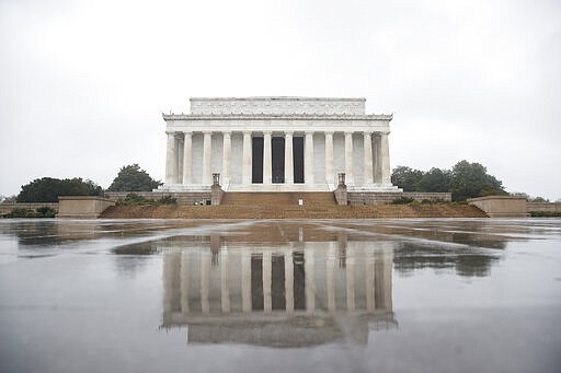 The Lincoln Memorial is seen on a rainy morning in Washington, Monday, March 23, 2020, as only a few National Park Police can be seen on the steps. As Washington continues to work to mitigate the spread of the coronavirus (COVID-19), Mayor Muriel Bowser extended road closures and other measures to restrict access to the Tidal Basin, the the cherry blossoms, and other tourist attractions. (AP Photo/Carolyn Kaster)