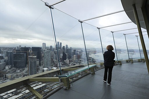 Seattle Mayor Jenny Durkan walks alone on the viewing deck of the Space Needle, which is closed to visitors, Thursday, March 26, 2020, in Seattle. Durkan later raised a flag that reads &quot;#We Got This Seattle&quot; on the roof of the landmark, and said it is intended to be a symbol of unity and encouragement as the city faces a state-wide stay-at-home mandate and one of the worst outbreaks of the new coronavirus in the U.S. The flag will fly from the Space Needle, which is closed to visitors, for at least several weeks. (AP Photo/Ted S. Warren)