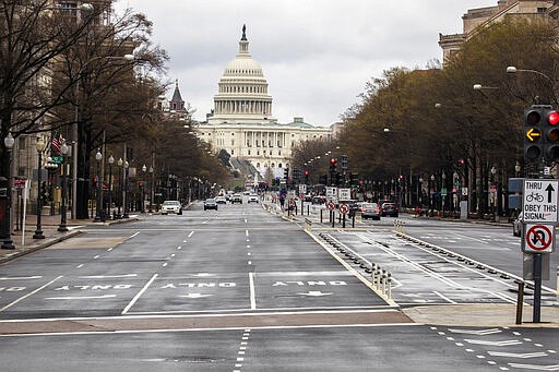 With the U.S. Capitol building in the background, motorists drive on Pennsylvania Avenue NW, Wednesday, March 25, 2020, in Washington. Officials have urged Washington residents to stay home to contain the spread of the coronavirus. (AP Photo/Manuel Balce Ceneta)