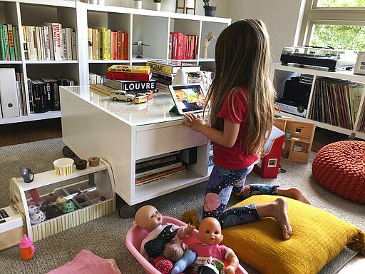 In this March 25, 2020, photo, Associated Press reporter Barbara Ortutay&#146;s daughter watches a video in her apartment during a shelter-in-place order in Oakland, Calif. (AP Photo/Barbara Ortutay)