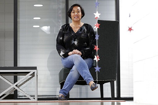 In this March 25, 2020, photo, Attorney Margarita Silva sits in her office in Phoenix. Silva was recently denied entry to a hearing inside an immigration detention center under a new requirement for lawyers to bring their own masks, protective eye gear and gloves to protect against coronavirus. While some immigration courts have closed, the Trump administration has insisted on keeping many open amid fierce resistance from judges and even Homeland Security Department attorneys. (AP Photo/Matt York)