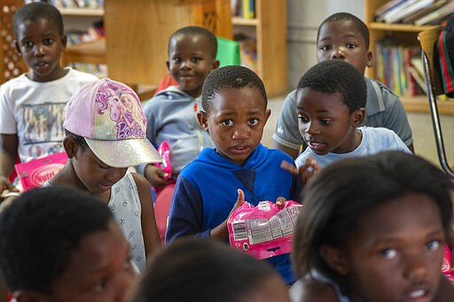 Children participate in a coronavirus awareness workshop held at the Qalakabusha center in the township of Soweto, near Johannesburg, South Africa, Thursday March 26, 2020, just hours before South Africa goes into a nationwide lockdown for 21 days, in an effort to control the spread to the coronavirus. The new coronavirus causes mild or moderate symptoms for most people, but for some, especially older adults and people with existing health problems, it can cause more severe illness or death. (AP Photo/Jerome Delay)