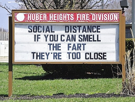 FILE - In this March, 25, 2020, file photo, a sign sits in front of the Huber Heights Fire Division in Huber Heights, Ohio. It may be a little awkward, but humor is helping people around the planet cope with the fear and anxiety the coronavirus pandemic has unleashed. (Marshall Gorby/Dayton Daily News via AP)