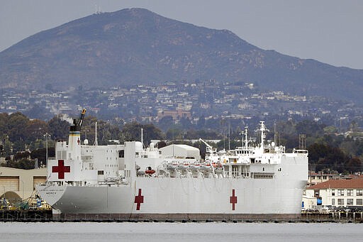 FILE - In this Wednesday, March 18, 2020, file photo, The USNS Mercy, a Navy hospital ship is seen docked at Naval Base San Diego in San Diego, Calif. To help combat an expected shortage of hospital beds as the virus spreads, the U.S. Naval hospital ship Mercy departed San Diego on Monday, March 23, bound for Los Angeles to treat non-coronavirus patients. The 1,000-bed USNS Mercy is expected to arrive in less than a week and begin accepting patients within a day of arrival, Capt. John R. Rotruck said. (AP Photo/Gregory Bull, File)