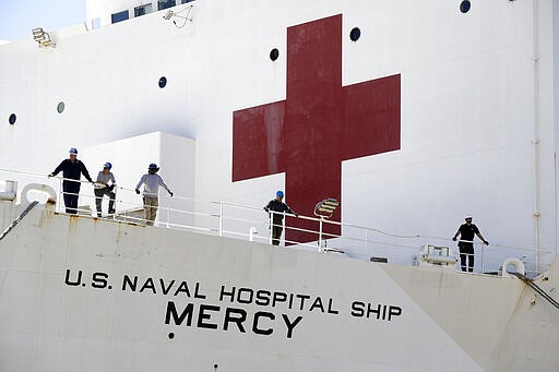 The USNS Mercy hospital ship sits at dock before its departure Monday, March 23, 2020, in San Diego. The Navy hospital ship was preparing to leave San Diego on Tuesday and planned to spend a few days at sea getting its newly formed medical team used to working together before arriving to Los Angeles to help the city free up its hospital beds, in efforts to help combat the coronavirus. (AP Photo/Gregory Bull)