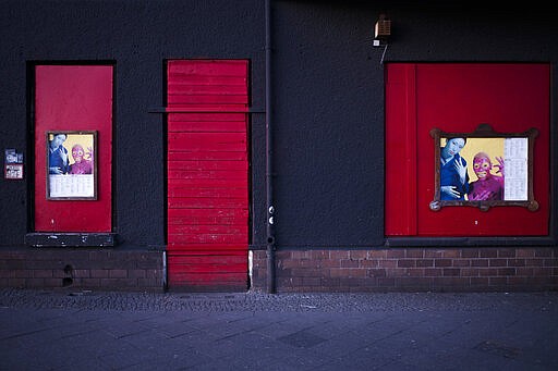 In this March 25, 2020, photo, signs are displayed near part of the front of the closed music club Wilde Renate, in Berlin, Germany. The nightclubs in the German capital have decided to keep the beat going &#151; at least online. Berlin's nightclubs were closed on March 13 in an attempt to slow the spread of the coronavirus. In response, some clubs formed a streaming platform to let DJs, musicians and artists continue to perform. (AP Photo/Markus Schreiber)