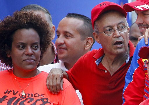 FILE - In this April 6, 2019 file photo, Luis Alfredo Motta Dominguez, right, attends a pro-government rally in Caracas, Venezuela. On Thursday, March 26, 2020, the U.S. Justice Department made public it has charged in several indictments against Venezuelan President Maduro and his inner circle, including Motta, that the leader has effectively converted Venezuela into a criminal enterprise at the service of drug traffickers and terrorist groups as he and his allies stole billions from the South American country.  (AP Photo/Ariana Cubillos, File)